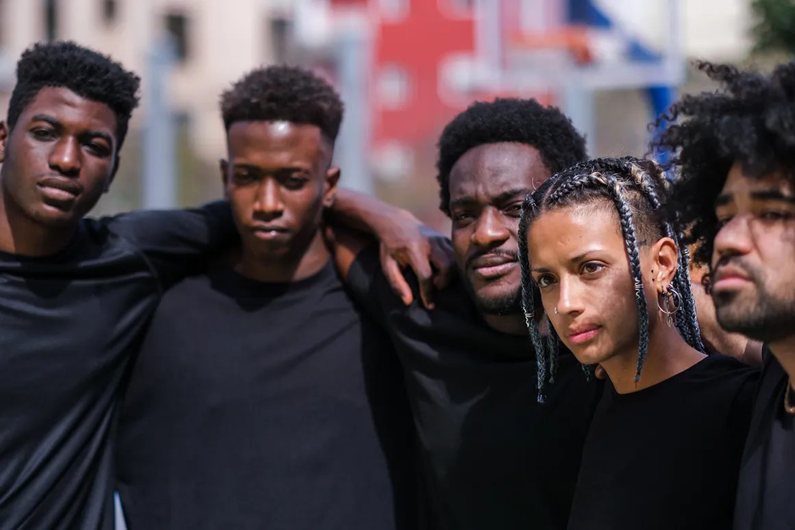 Groupe de jeunes créateurs et influenceurs posant ensemble en extérieur, symbole de communauté et de collaboration.